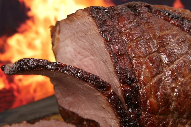 Braten mit Feuer im Hintergrund Braten mit Feuer im Hintergrund